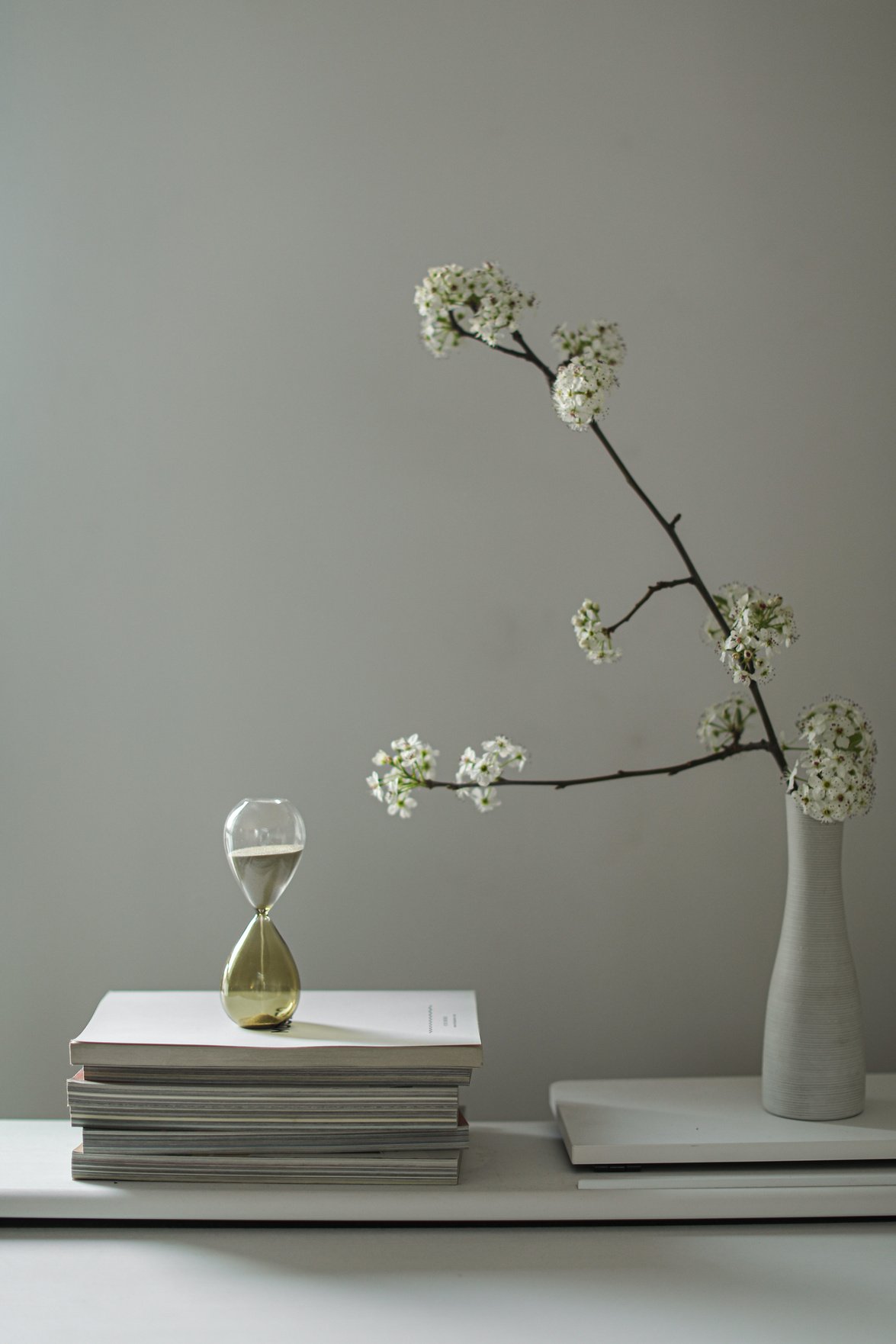 A Flower Vase and Hourglass Over Books